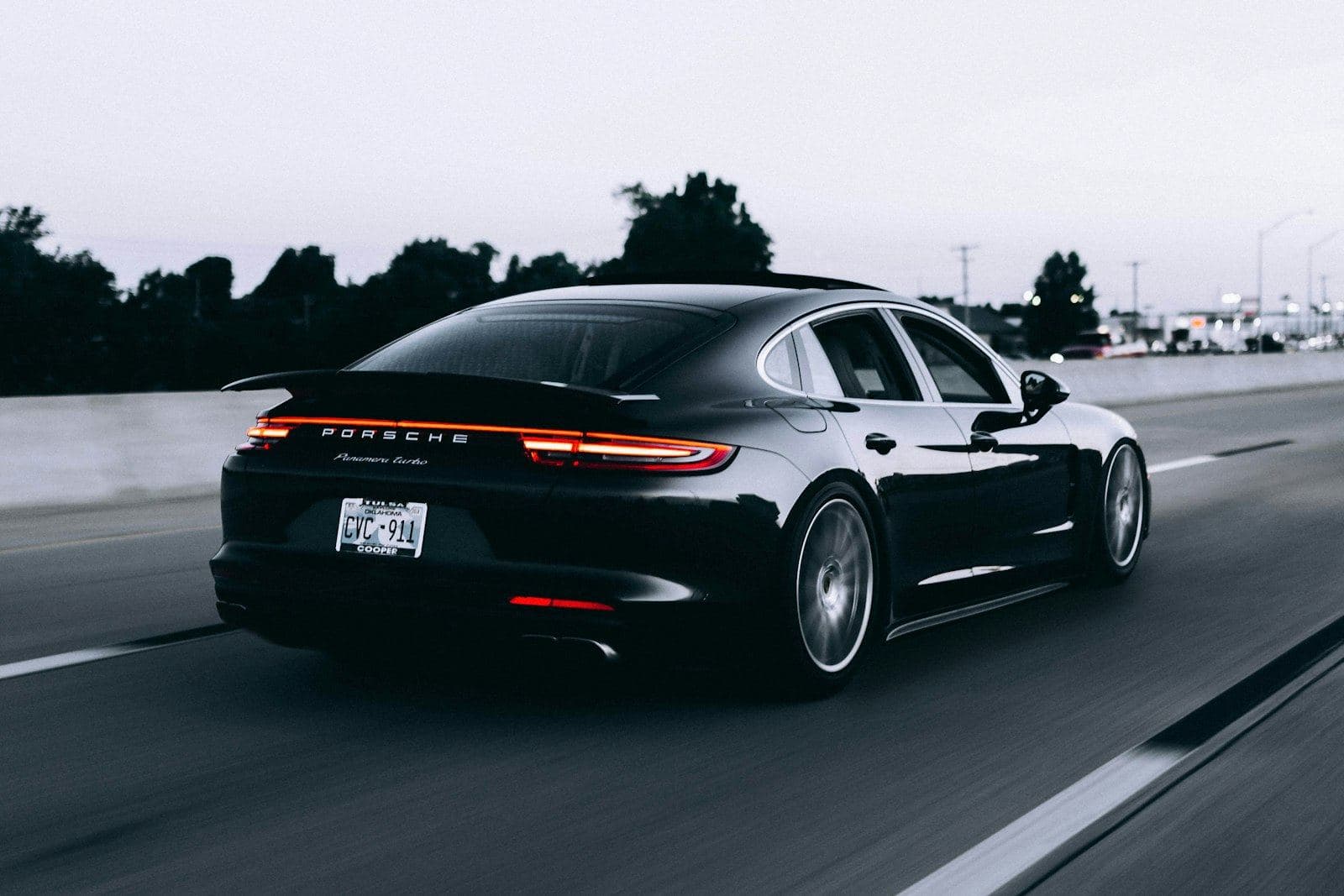 A chauffeured sedan on the move at dusk